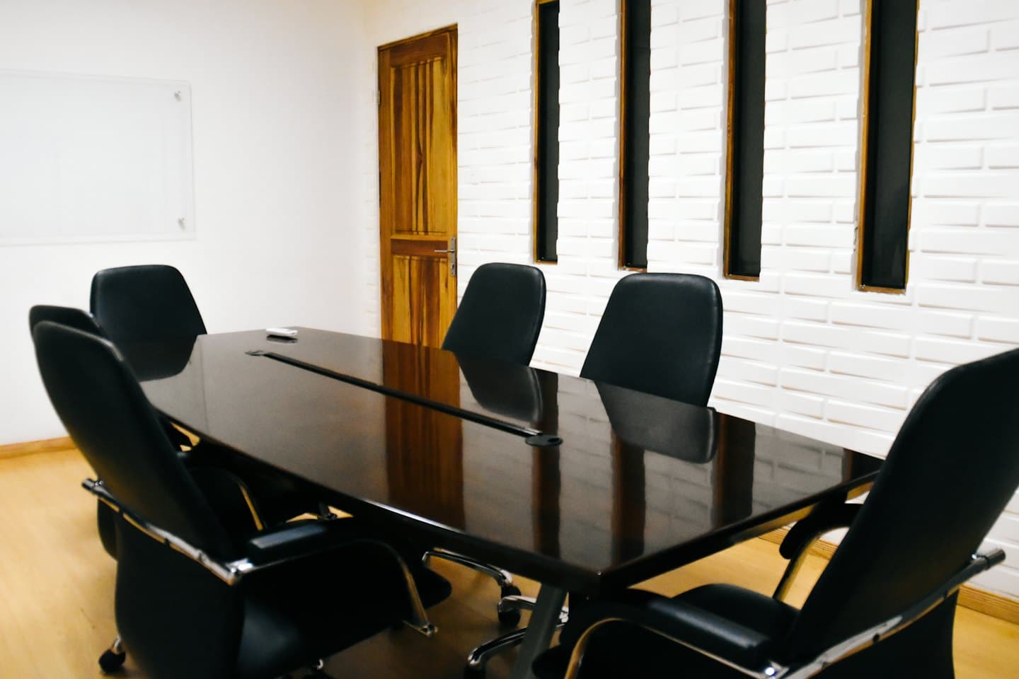 Empty corporate meeting room with a large conference table and chairs.