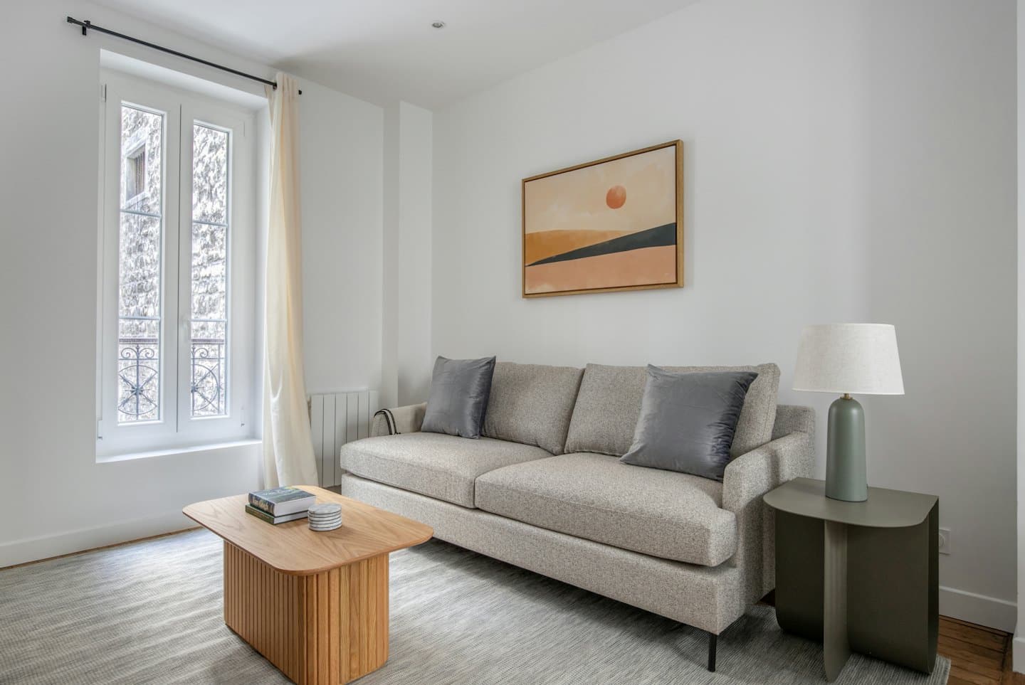 Modern living room with grey sofa and wooden coffee table.
