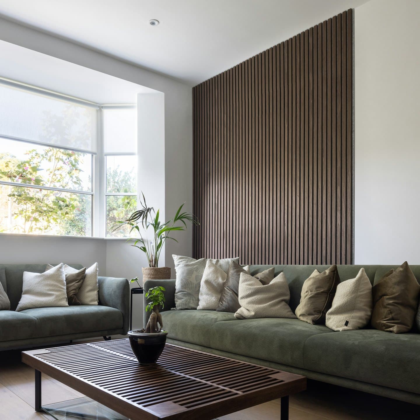 Modern living room with green velvet sofas and wooden coffee table.