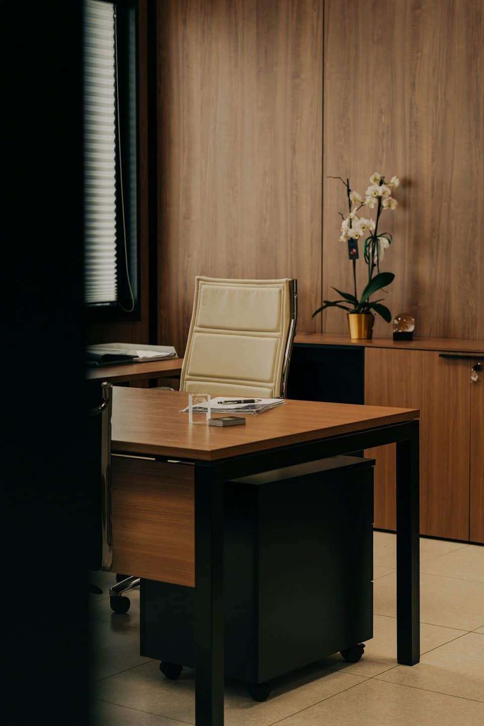 Modern office desk and chair with a white orchid.