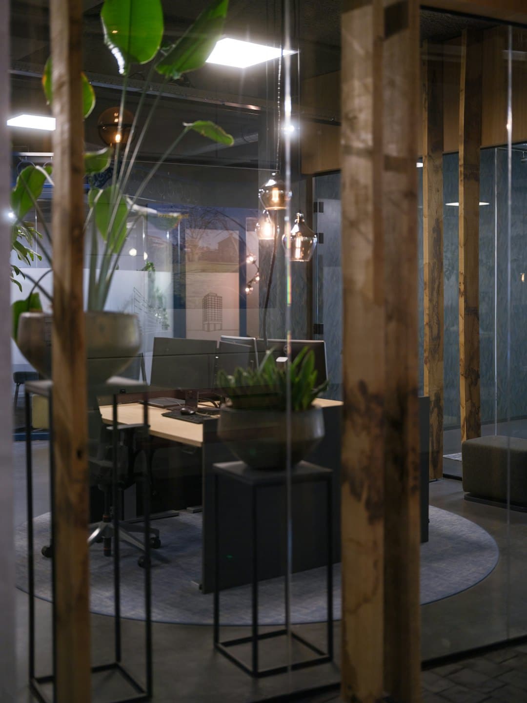 Modern office desks and chairs seen through glass.