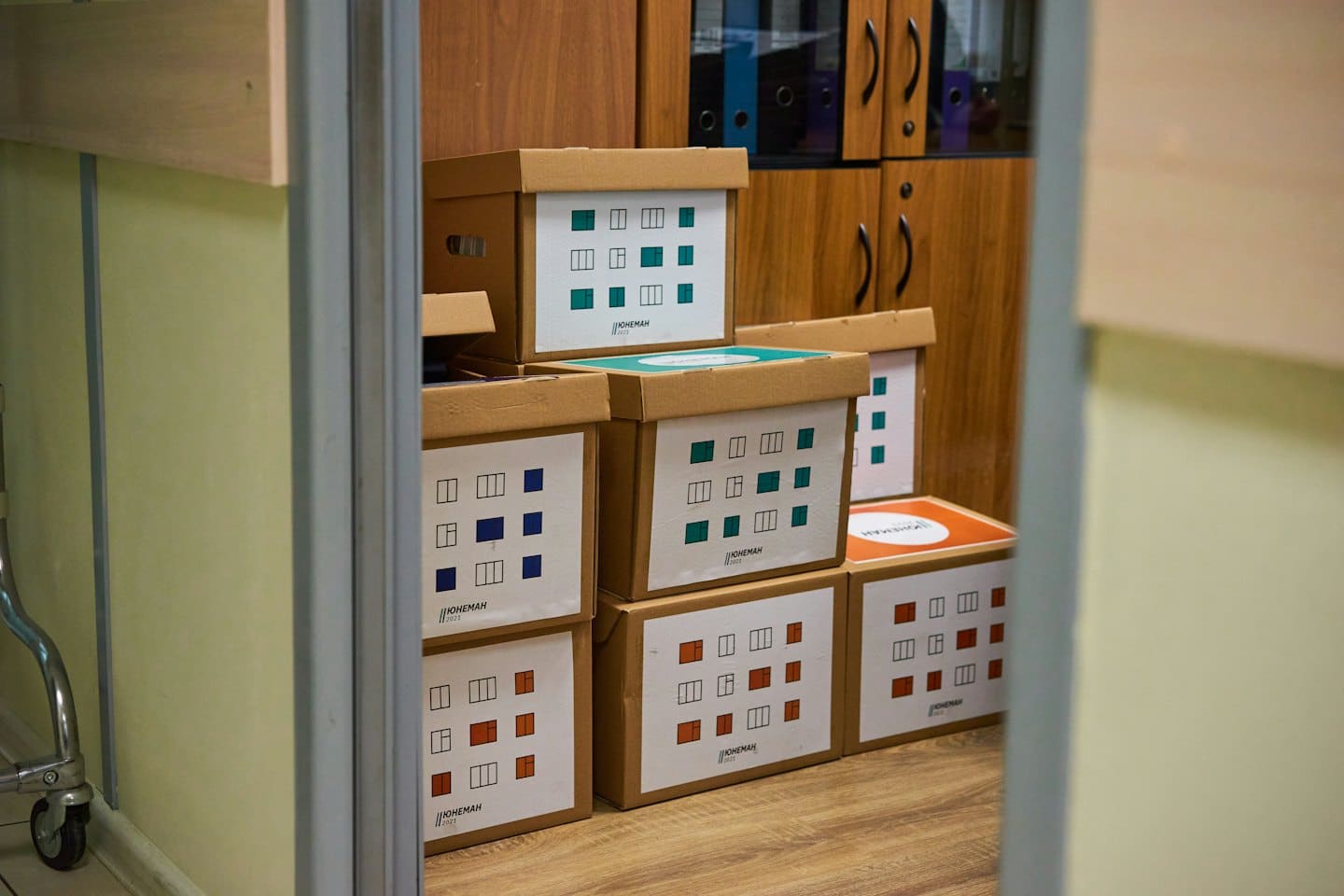 Cardboard archive boxes stacked neatly in an office storage room.